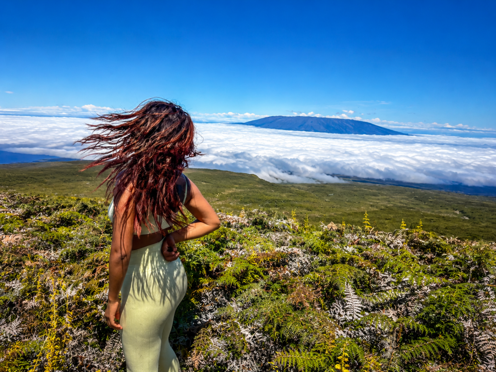 Woman overlooking a volcanic landscape and sea of clouds in the Galápagos