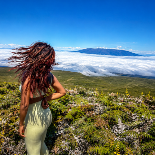 Woman overlooking a volcanic landscape and sea of clouds in the Galápagos