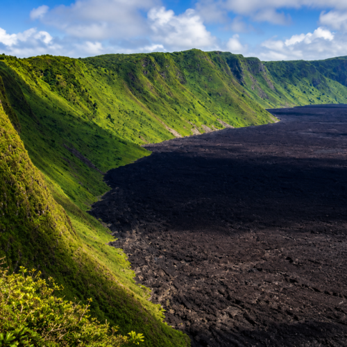 Galápagos volcanic caldera with black lava field and lush green crater walls