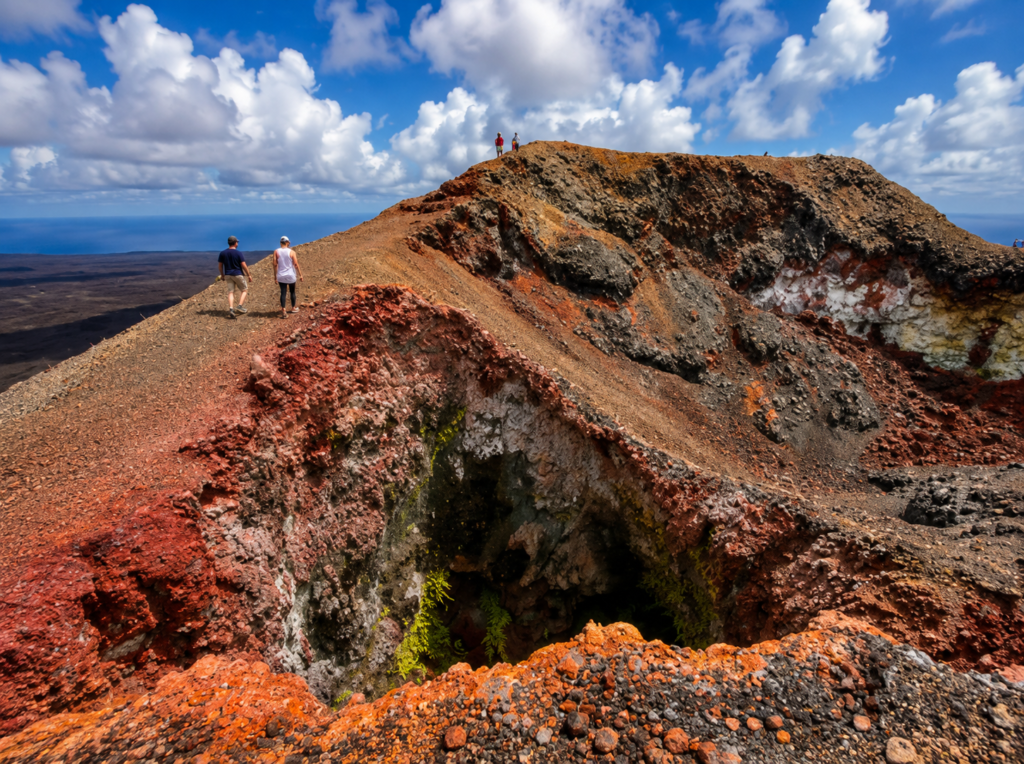 Hikers exploring a colorful volcanic crater in the Galápagos