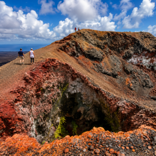 Hikers exploring a colorful volcanic crater in the Galápagos