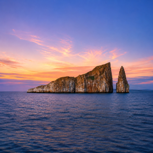 Galápagos rock formation rising from the ocean beneath a colorful sunset sky