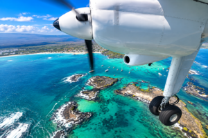 Small aircraft flying over the turquoise waters and islands of the Galápagos